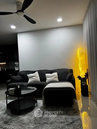 Modern living room with cozy black sofa and stylish lighting