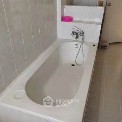 Spacious bathroom with built-in bathtub and modern fixtures.