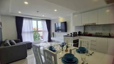Modern open-plan living room and kitchen with sleek design and natural light.