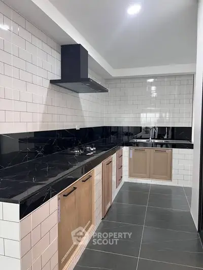 Modern kitchen with sleek black countertops and gas stove