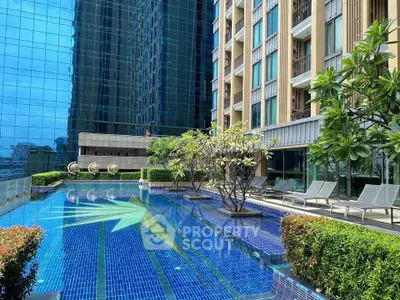 Luxurious modern apartment building with stunning outdoor pool and lush greenery.