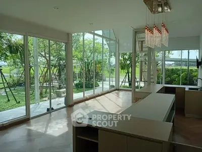 Spacious modern living room with floor-to-ceiling windows and garden view