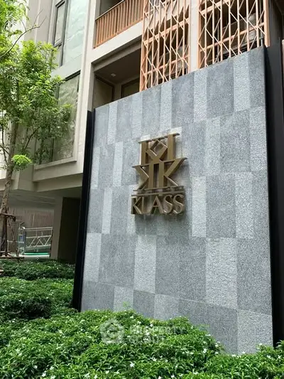 Modern building exterior with stylish facade and lush greenery at Klass residence.
