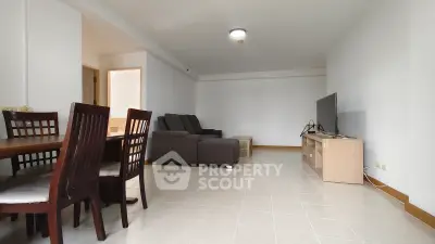 Spacious living room with modern furniture and tiled flooring, perfect for family gatherings.