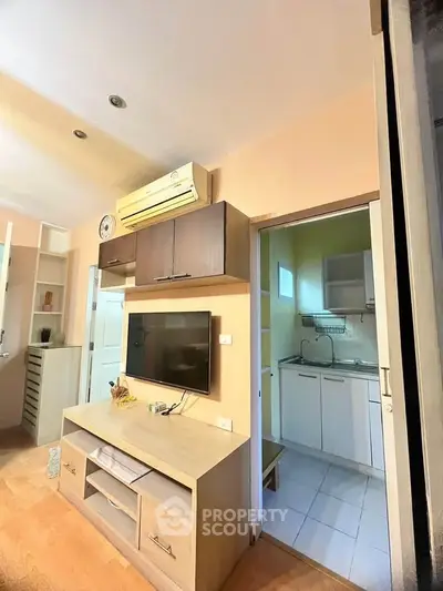 Cozy living room with wall-mounted TV and open kitchen view