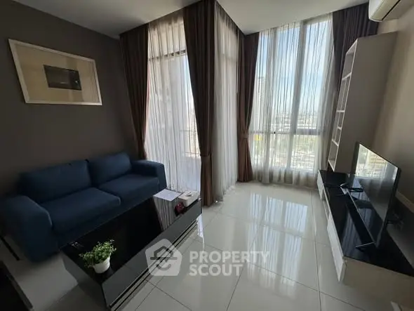 Modern living room with large windows and stylish furniture in a high-rise apartment.