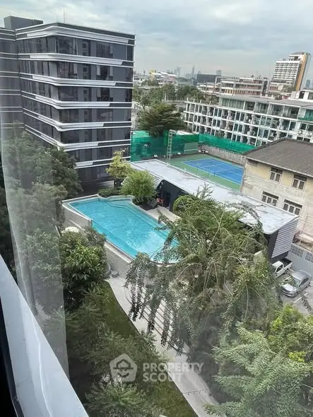 Stunning aerial view of modern residential complex with pool and lush greenery.