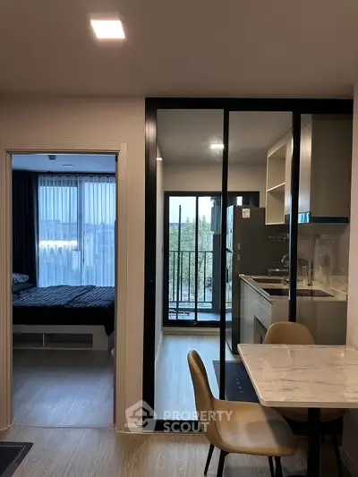 Modern apartment interior with kitchen, dining area, and balcony view.