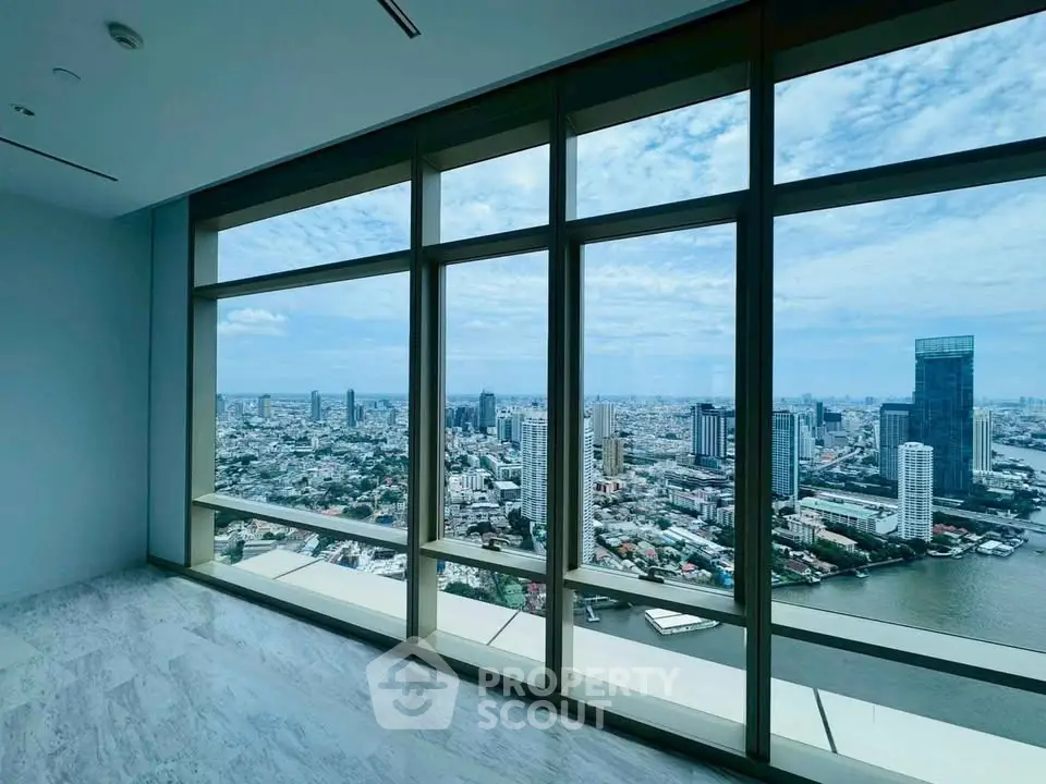 Stunning high-rise apartment with panoramic city and river views through floor-to-ceiling windows.