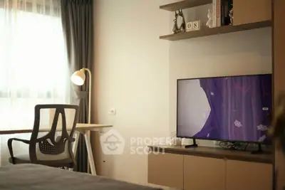Modern bedroom with study area and TV, featuring stylish decor and natural light.