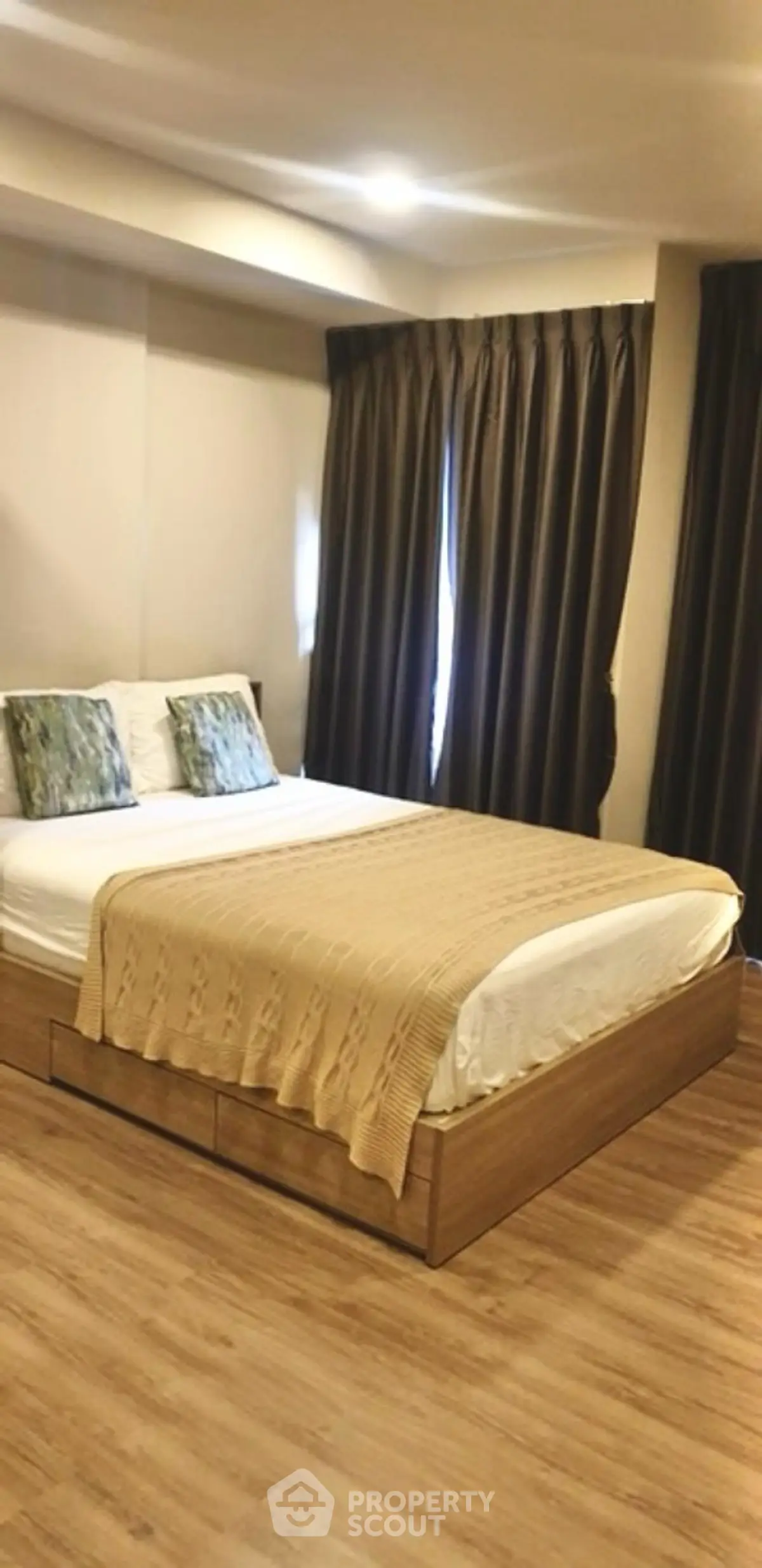 Cozy modern bedroom with wooden flooring and elegant curtains