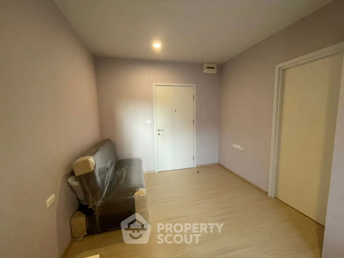 Minimalist room with light wood flooring and a wrapped sofa, ideal for modern living.