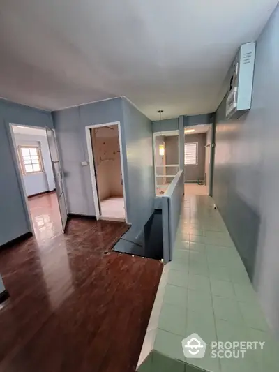 Spacious hallway with wooden flooring and modern lighting in a residential property