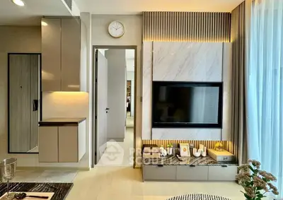 Modern living room with stylish decor and large TV, featuring elegant lighting and contemporary furniture.