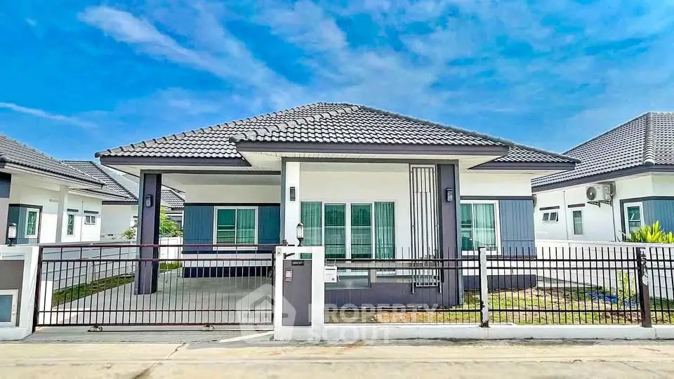 Modern single-story house with sleek design and spacious driveway in a serene neighborhood.