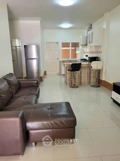 Modern open-plan living room and kitchen with sleek furniture and appliances.