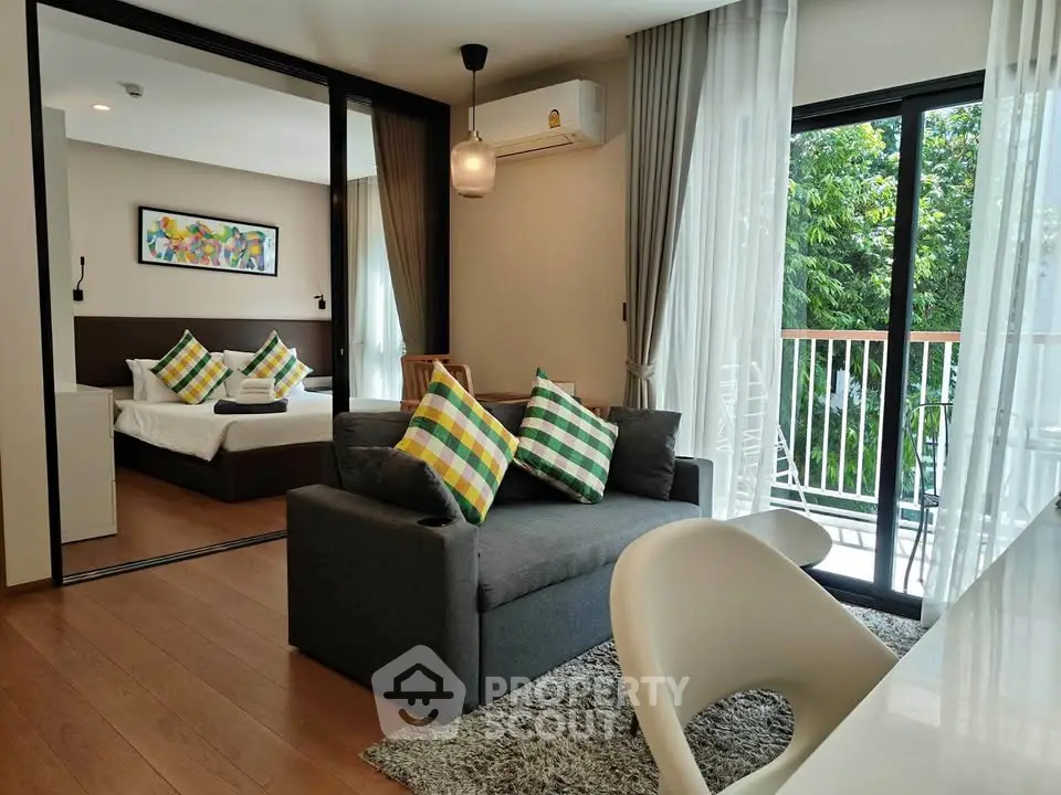 Modern living room with balcony access and stylish decor in a cozy apartment.