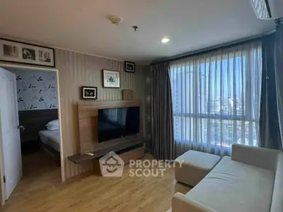 Modern living room with large window and stylish decor in a high-rise apartment.