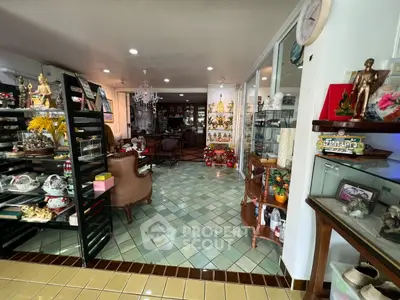Charming interior with eclectic decor and tiled flooring, featuring cozy seating and decorative shelves.