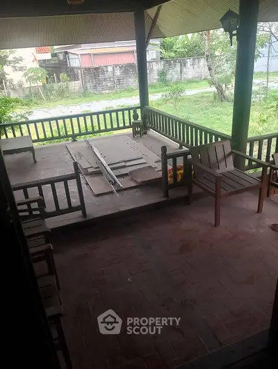 Charming rustic porch with wooden furniture and garden view, perfect for relaxation.