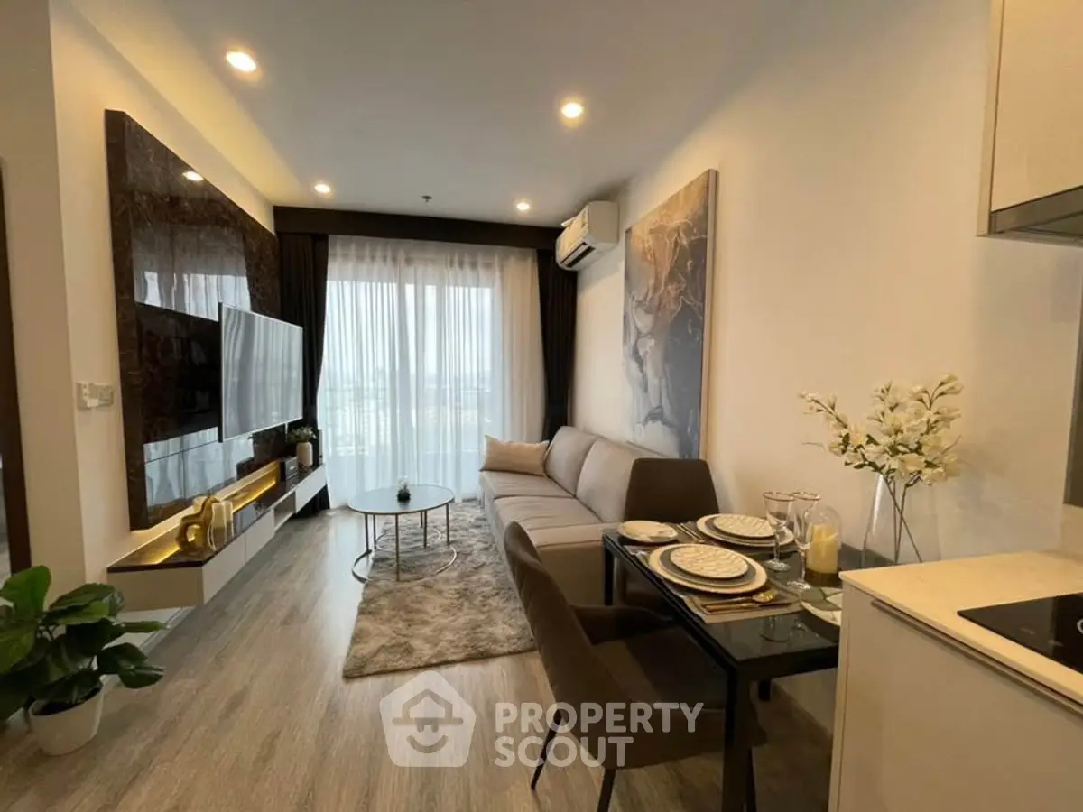 Modern living room with stylish decor and open layout, featuring a cozy sofa and large TV.