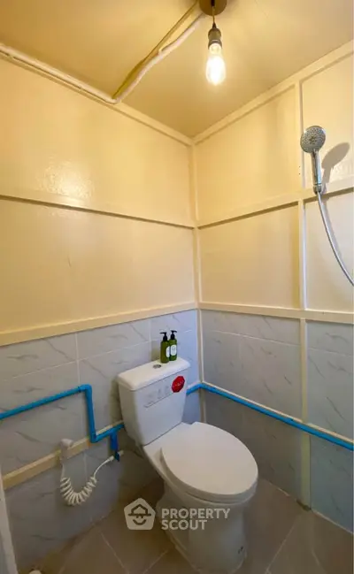 Compact bathroom with modern fixtures and overhead shower