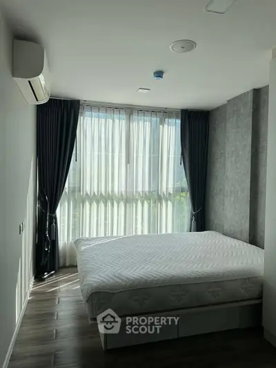 Modern bedroom with large windows and stylish decor in a luxury apartment.