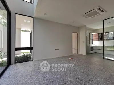 Modern open-plan living area with large windows and sleek kitchen design