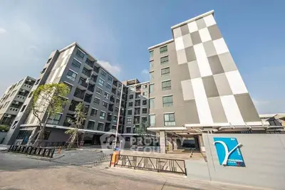 Modern apartment building exterior with spacious parking area and contemporary design.