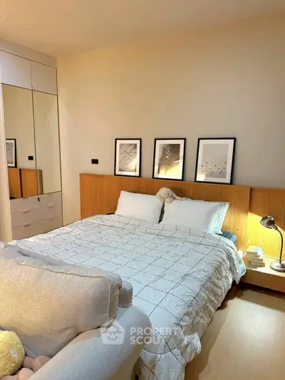 Cozy bedroom with modern decor and soft lighting, featuring a comfortable bed and stylish artwork.