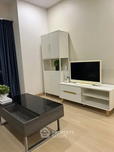 Modern living room with sleek furniture and TV setup, perfect for relaxation and entertainment.