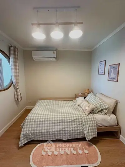 Cozy bedroom with stylish decor and soft lighting, featuring a comfortable bed and modern air conditioning.