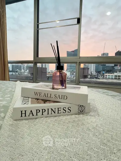 Cozy bedroom with city view, featuring stylish decor and large windows.