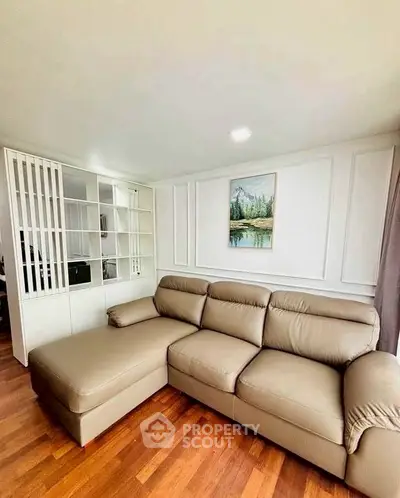 Spacious living room with elegant sectional sofa and wooden flooring