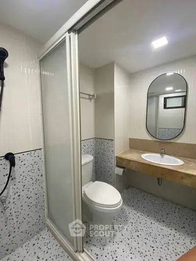 Modern bathroom with sleek shower and elegant vanity in a stylish apartment.