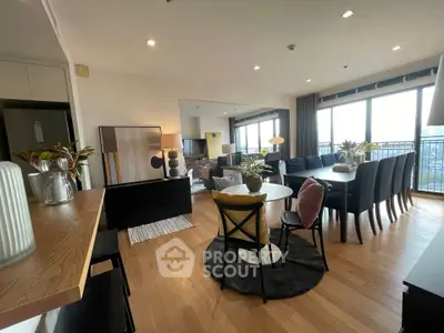Spacious modern living room with dining area and large windows offering city views.