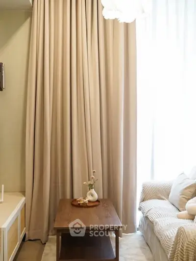 Cozy living room with elegant curtains, wooden coffee table, and comfortable sofa, perfect for relaxation.