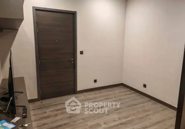 Minimalist empty room with wooden flooring and modern door