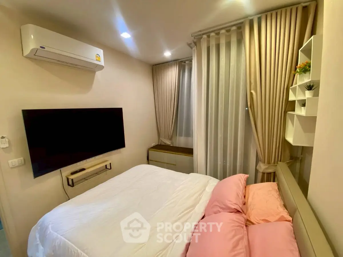 Cozy bedroom with modern air conditioning and large TV, perfect for relaxation.