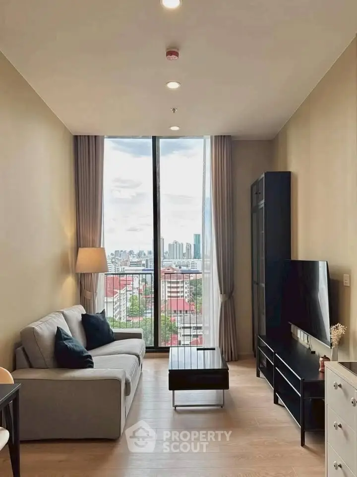 Modern living room with city view, stylish furniture, and floor-to-ceiling windows.