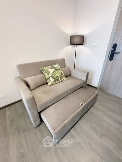 Modern living room with stylish sofa and floor lamp in cozy apartment.