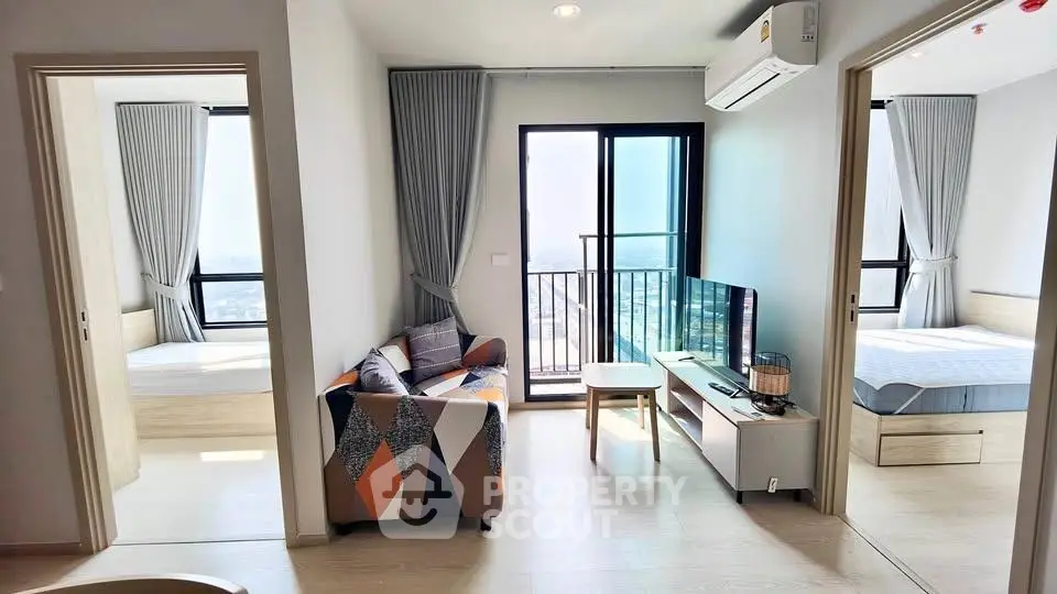 Modern apartment living room with balcony and two bedrooms, featuring stylish decor and natural light.