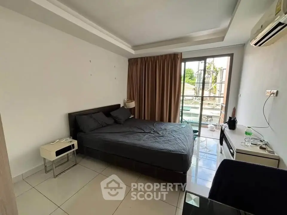 Modern bedroom with balcony access and sleek furnishings in a stylish apartment.