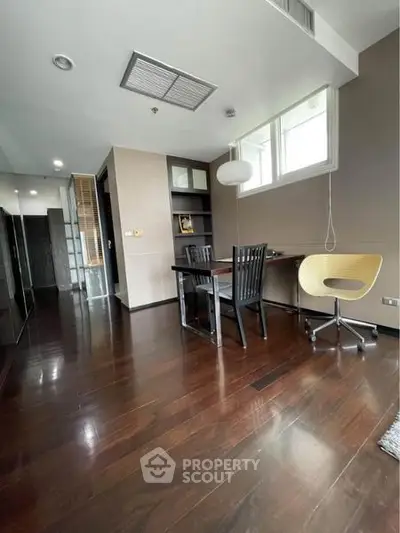 Modern study room with wooden flooring and stylish furniture in a contemporary apartment.