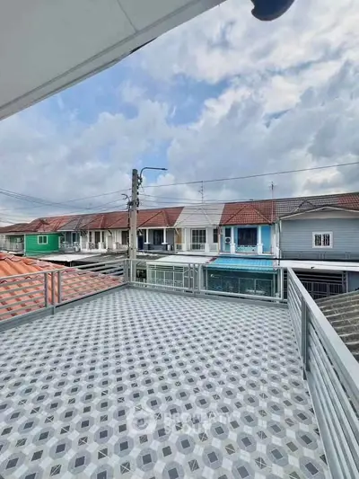 Spacious balcony with patterned tiles offering a panoramic view of a residential neighborhood.