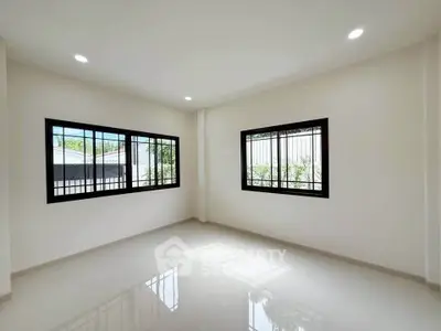 Bright and spacious empty room with large windows and glossy floor, perfect for customization.