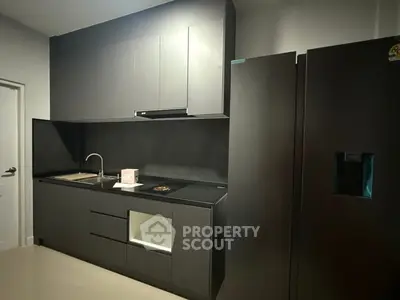 Sleek modern kitchen with dark cabinetry and built-in appliances