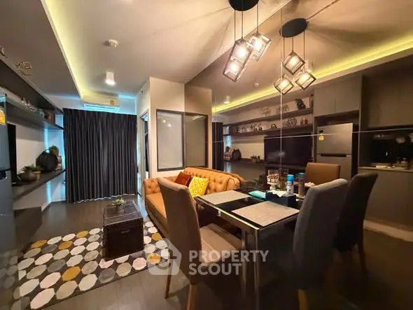 Modern living room with stylish lighting and open kitchen layout, perfect for urban living.