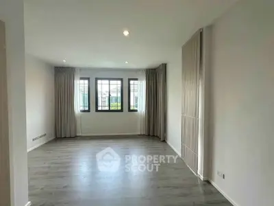 Spacious empty living room with large windows and elegant curtains, perfect for customization.