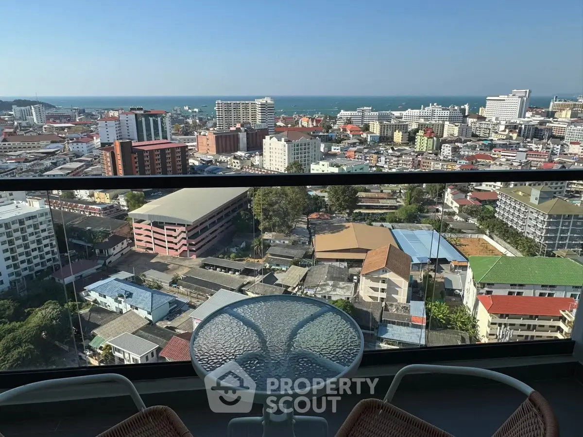 Stunning high-rise balcony view overlooking cityscape and ocean horizon, perfect for urban living.